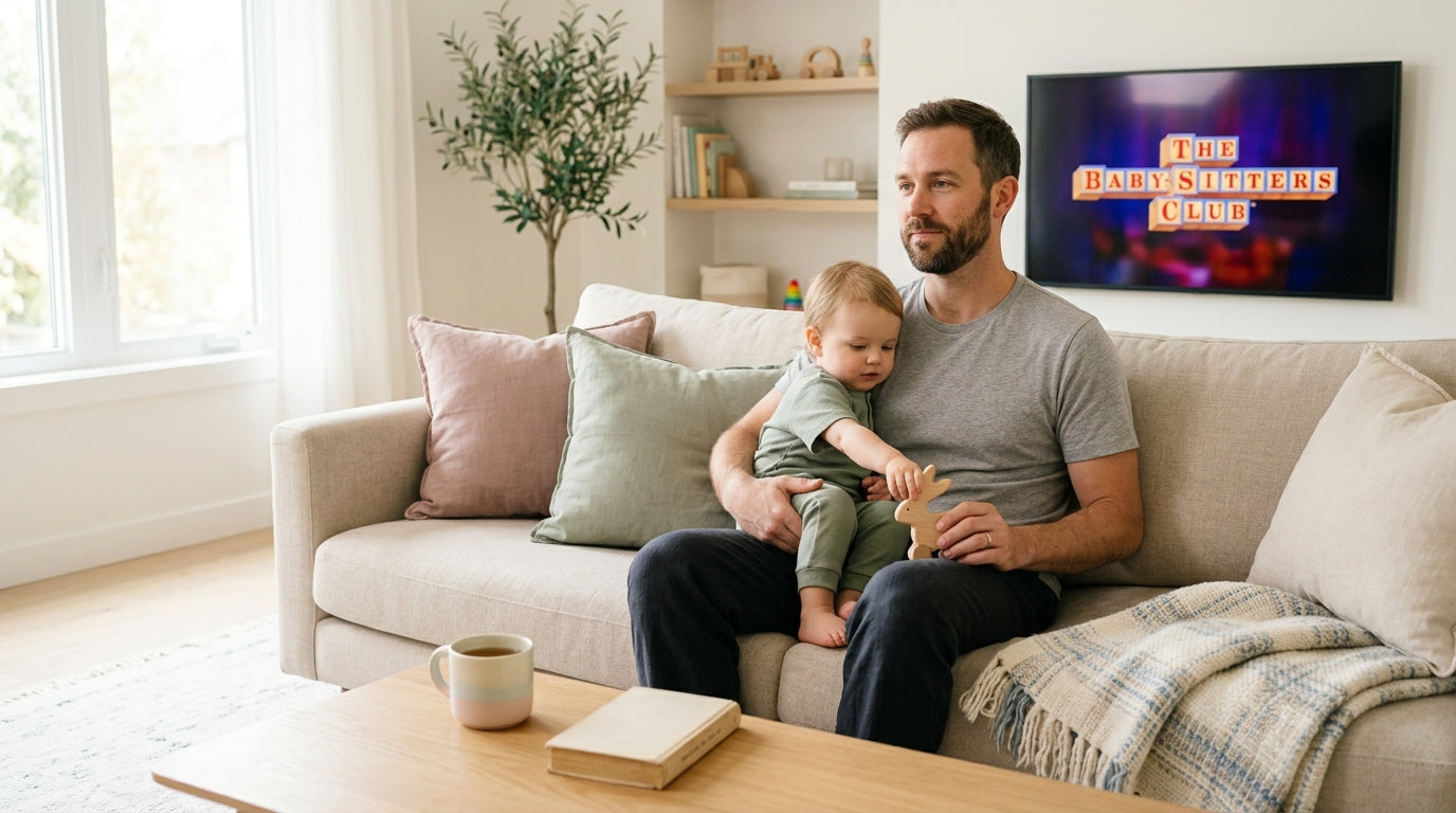 A stressed dad watching a movie while an 11-month-old baby plays on the floor