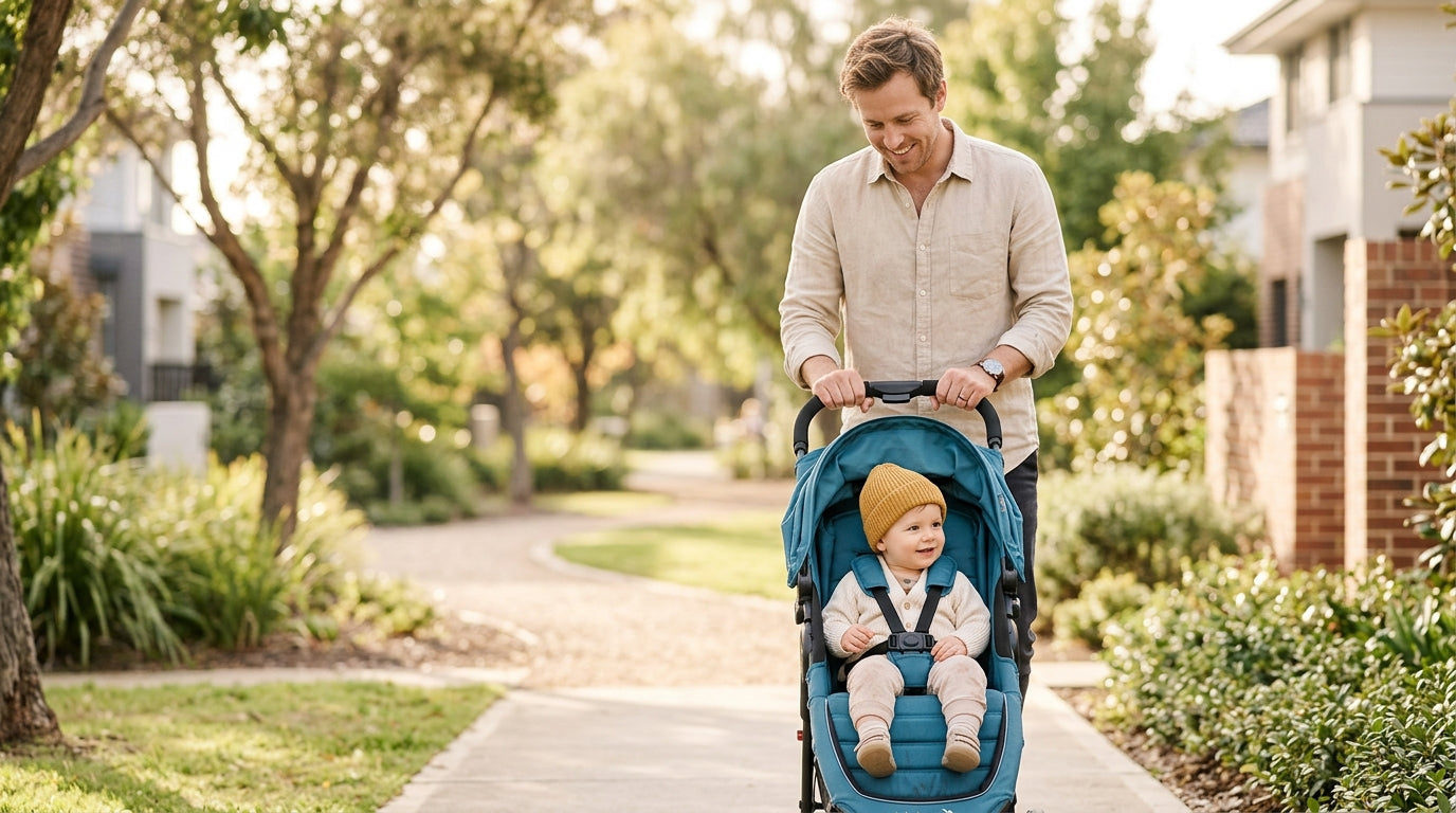 A dad looking at his phone while his baby plays with a teether in a coffee shop