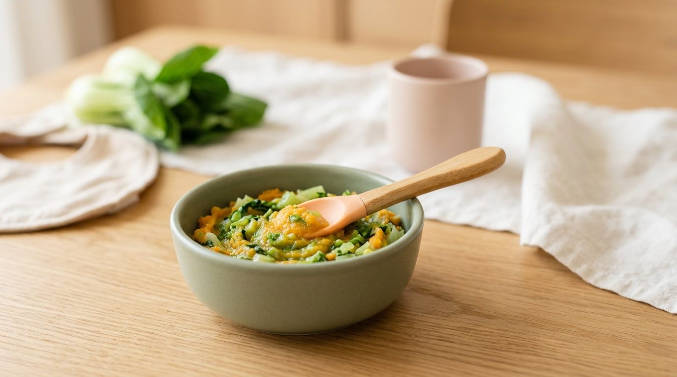 Steamed baby bok choy cut into small pieces on a silicone baby plate