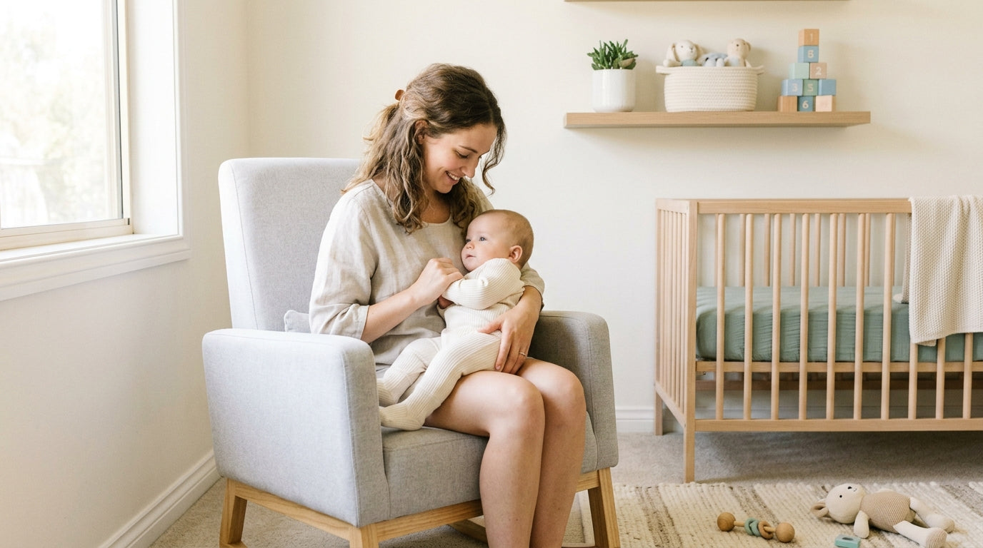 Tired dad typing on laptop while baby sleeps next to organic play gym