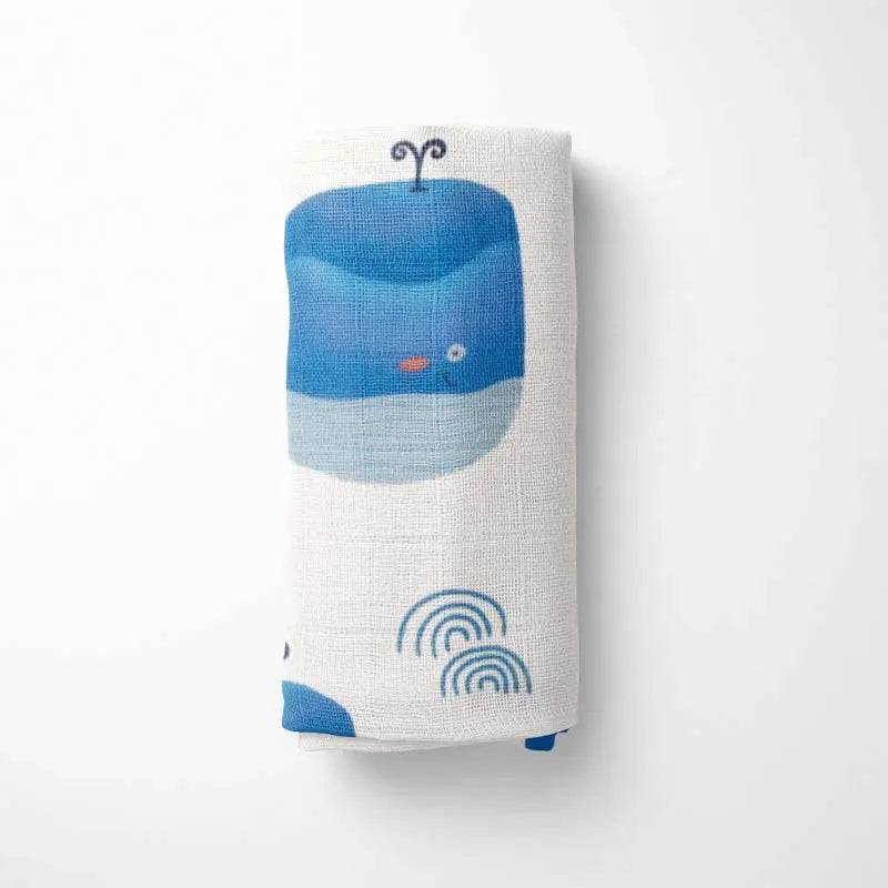 Rolled Ocean Blue happy whale baby blanket with premium bamboo fabric - ultra-soft, hypoallergenic and eco-friendly design.
