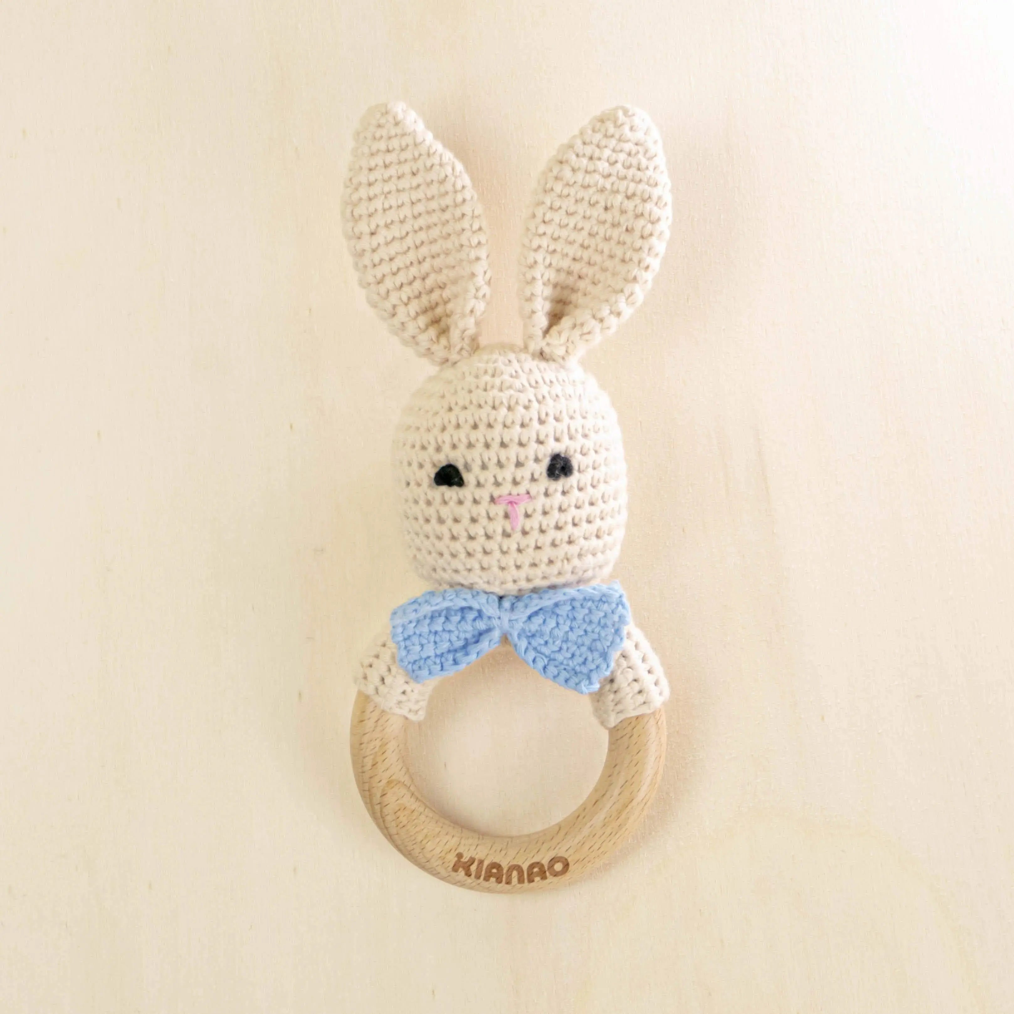 beige crochet bunny teething rattle with blue bow tie and wooden ring, handmade baby teether toy with long ears