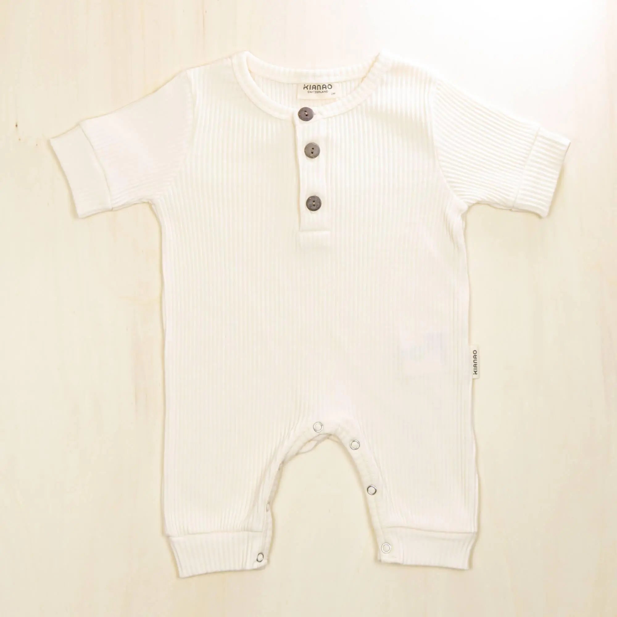 blossom white organic cotton baby henley romper with gentle elastic leg cuffs for unrestricted movement