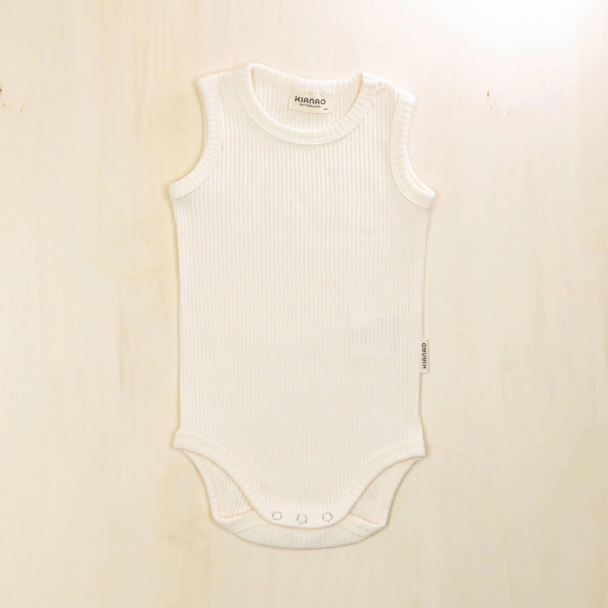 blossom white organic cotton baby bodysuit with stretchy neckline and envelope shoulders for easy dressing