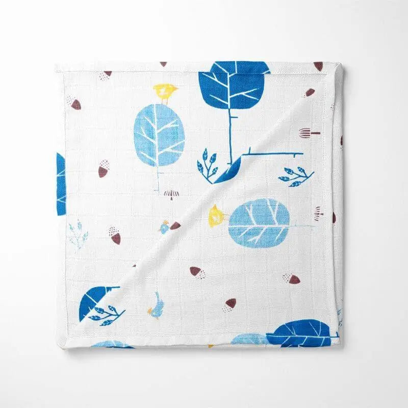 folded bamboo baby blanket featuring Scandinavian-inspired blue foxes and abstract leaves on white background with soft grid texture