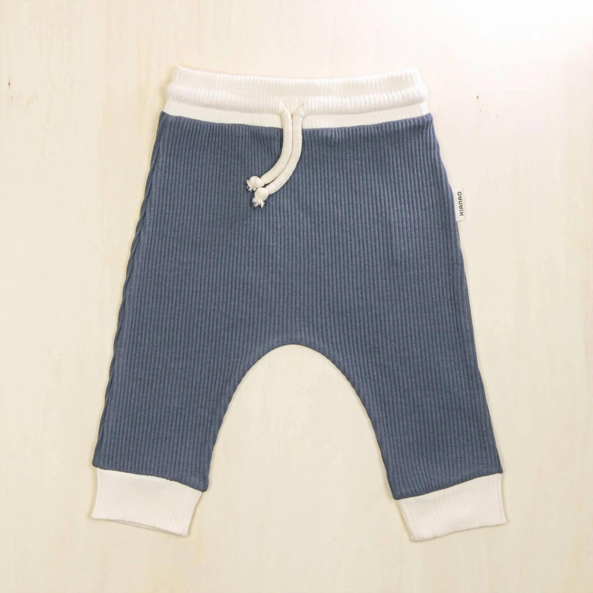 indigo blue organic cotton baby pants with white contrast waistband and cuffs, retro jogger style with drop-crotch design