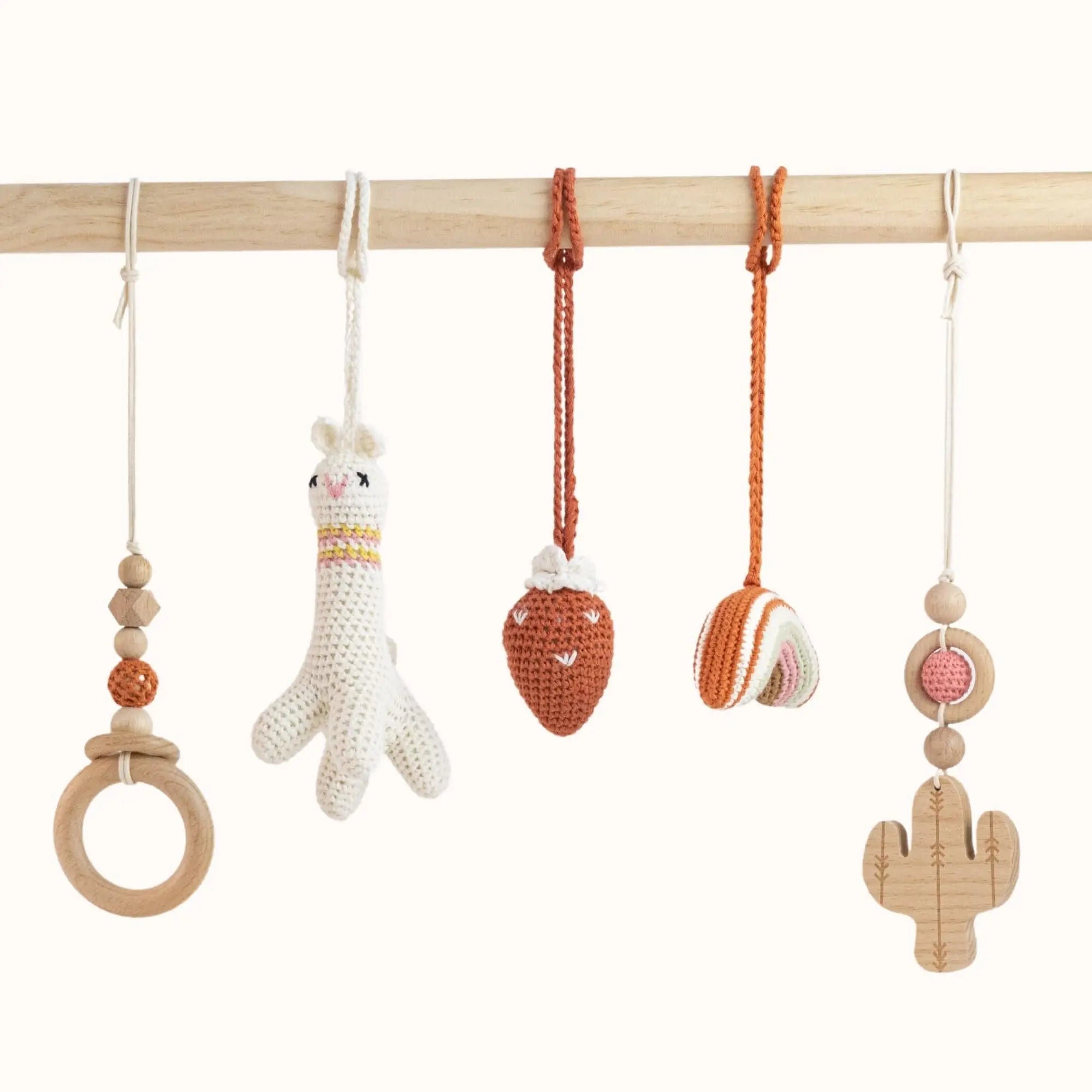 Close-up of Lama with Strawberry Play Gym toys showing detailed crochet work and natural wooden elements