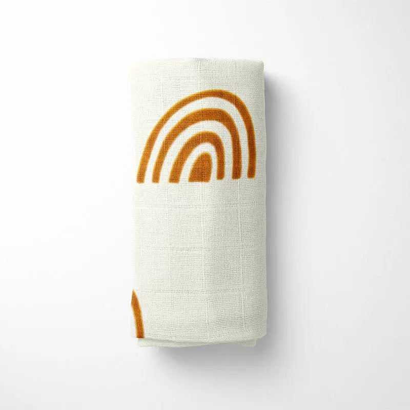closeup of mono rainbow bamboo baby blanket showing detail of earthy terracotta arches and organic fabric texture