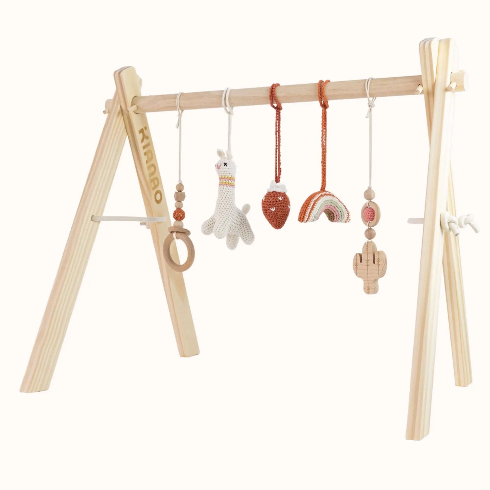 Natural wooden baby gym with handcrafted crochet toys including lama figure, strawberry, and wooden cactus on A-frame design