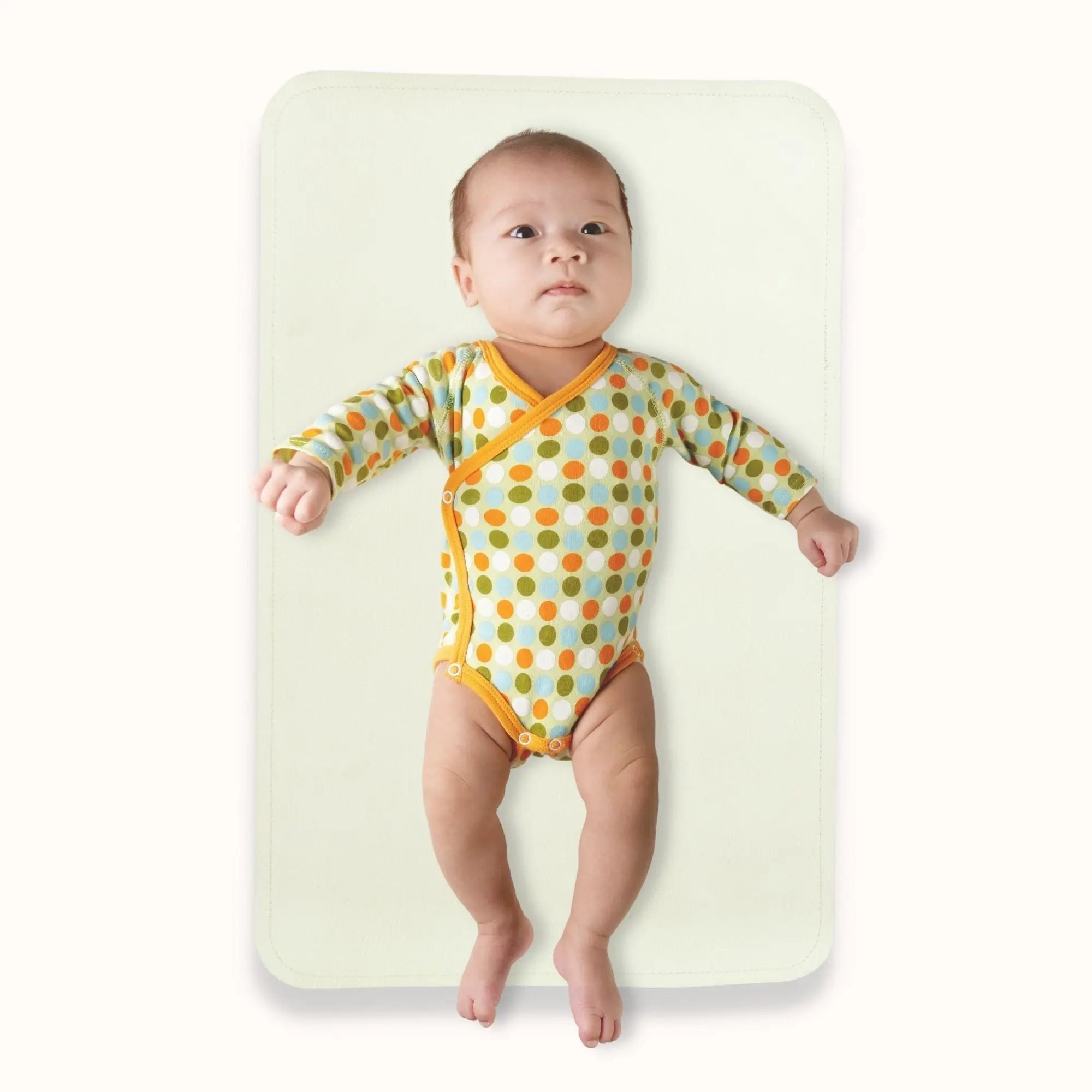 baby resting comfortably on soft waterproof surface of oat cream changing mat