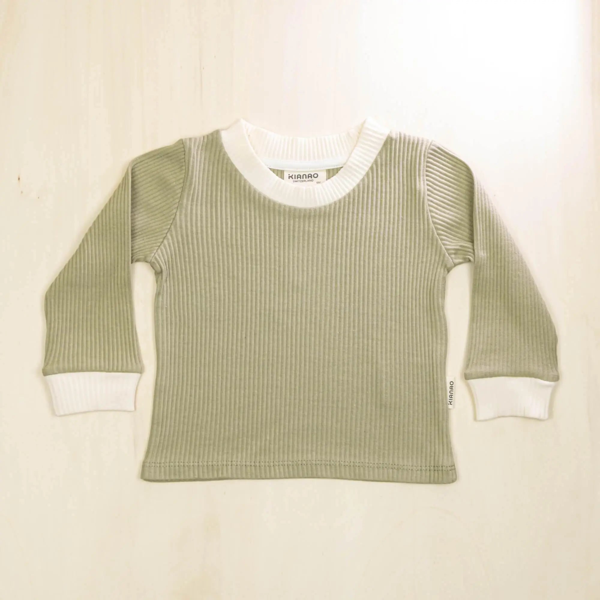 sage green organic cotton baby sweater with white contrast collar and cuffs, soft sustainable fabric for sensitive skin