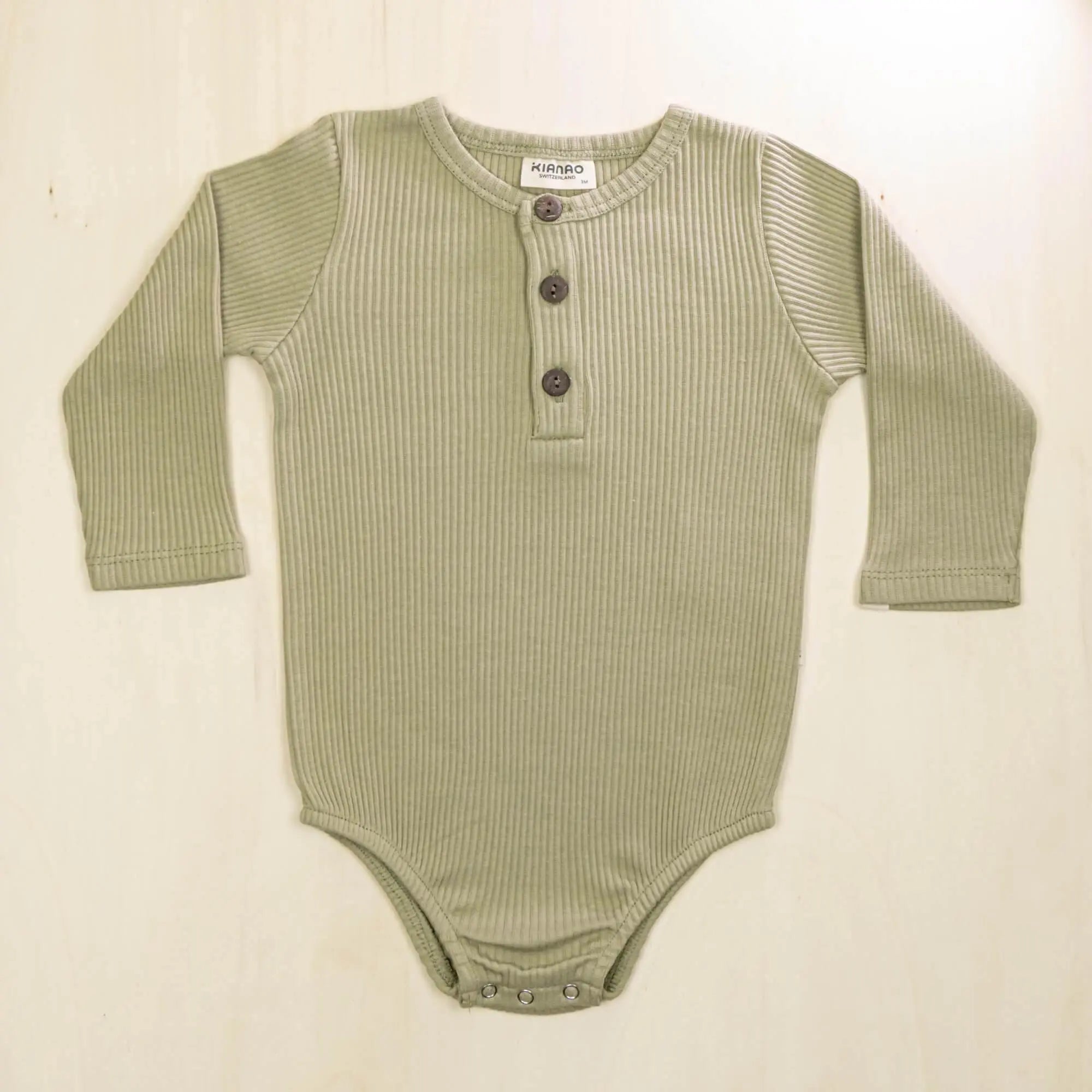 sage green organic cotton long sleeve baby romper with convenient button front design for quick changes