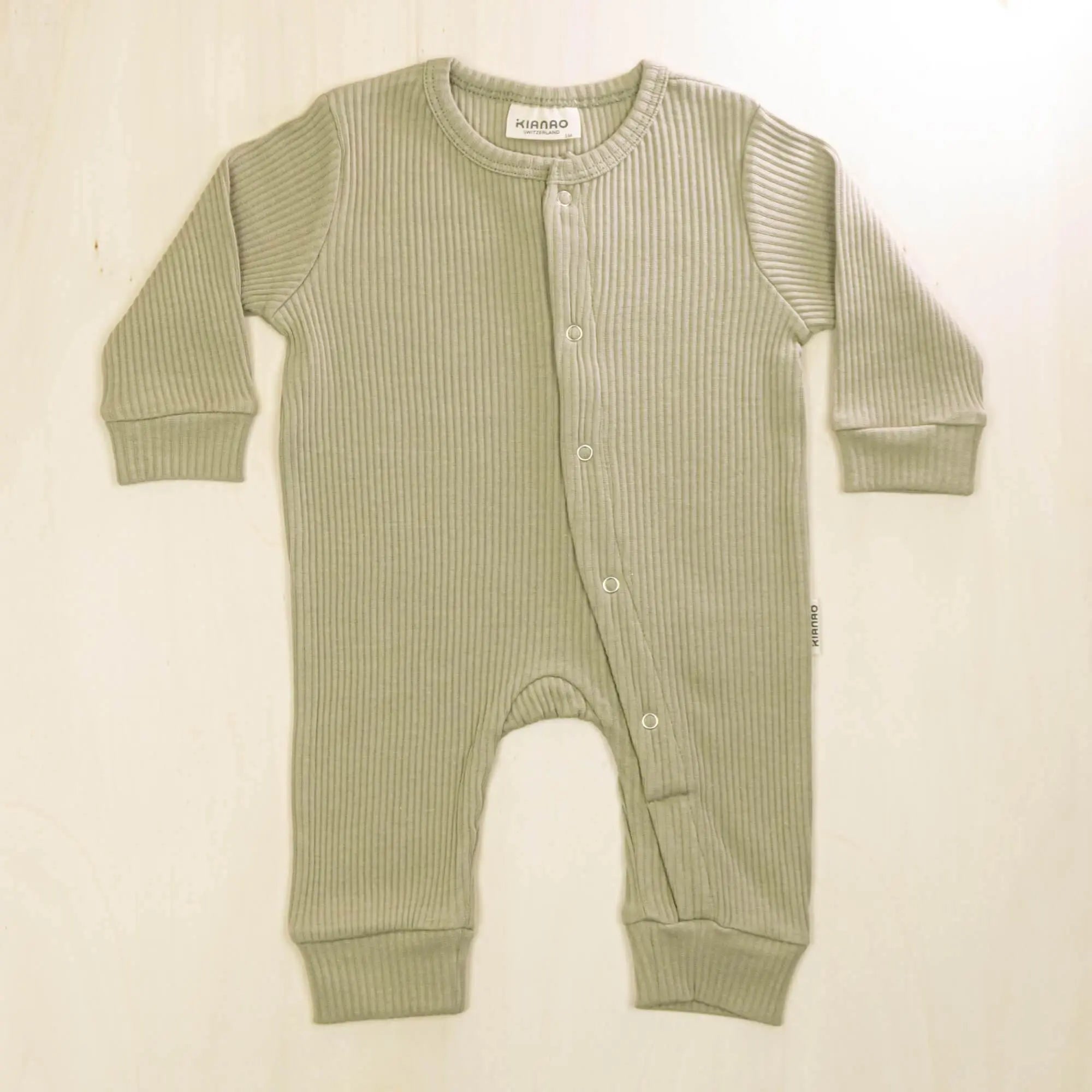 sage green organic cotton baby romper with front buttons and stretchy cuffs for all-day comfort