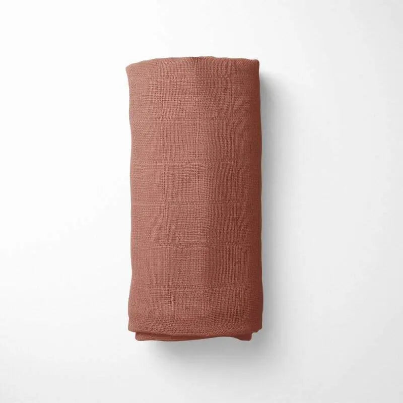 rolled with terracotta bamboo blanket during nap time, demonstrating the blanket's drape and comfort