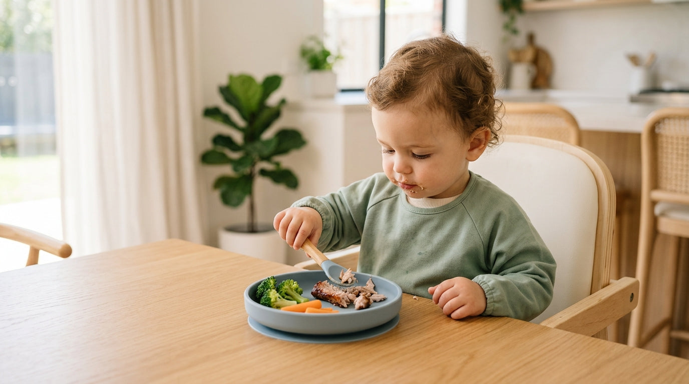 Toddler twins covered in BBQ sauce holding stripped pork ribs at a highchair