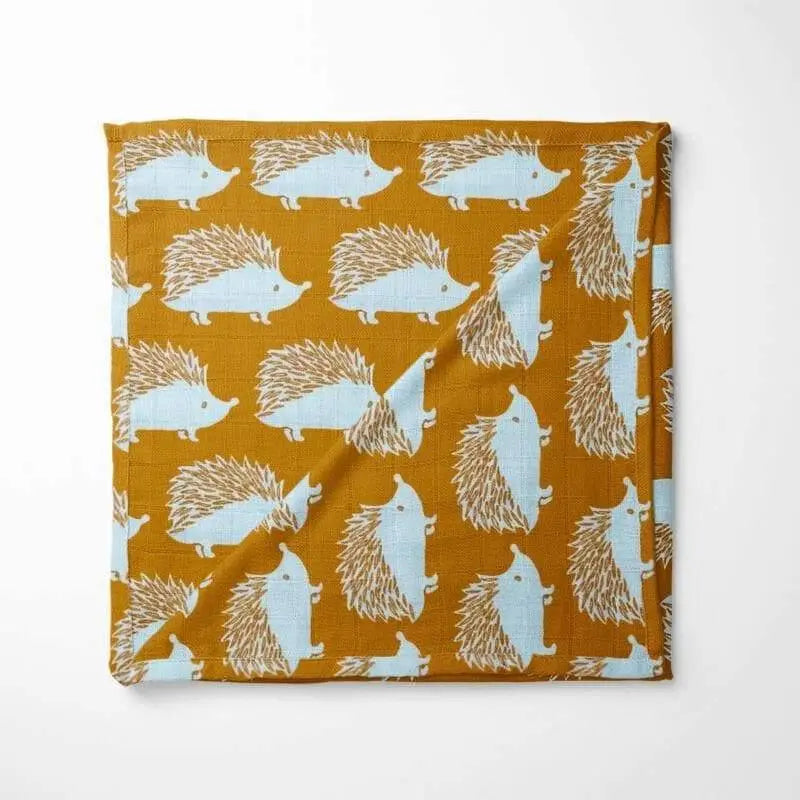 Folded mustard yellow organic cotton baby blanket showing hedgehog pattern and edge detail - soft breathable fabric for all-season comfort