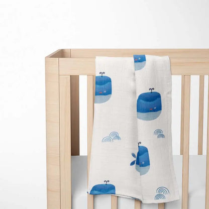 Hanging on bed Ocean Blue happy whale baby blanket with premium bamboo fabric - ultra-soft, hypoallergenic and eco-friendly design.