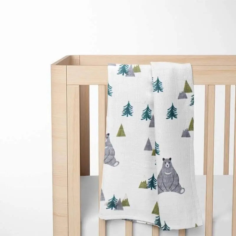 bear pattern bamboo baby blanket displayed on wooden crib showing size and drape with woodland design perfect for nursery decor