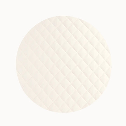 Close-up of cream-colored quilted vegan playmat showing soft texture for baby's comfort during play