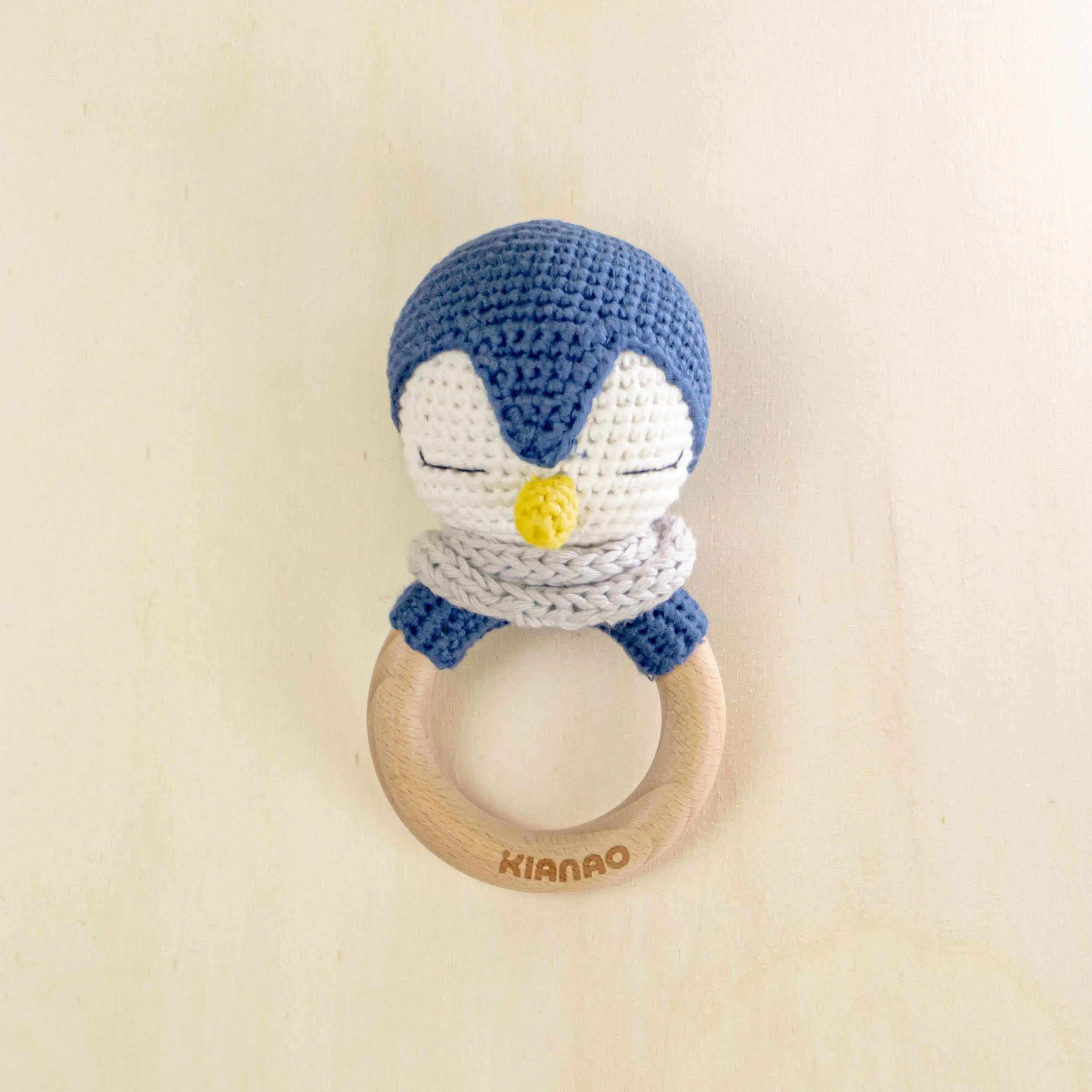 blue and white crochet penguin rattle tooth ring with natural wooden teether for sensory development and teething relief