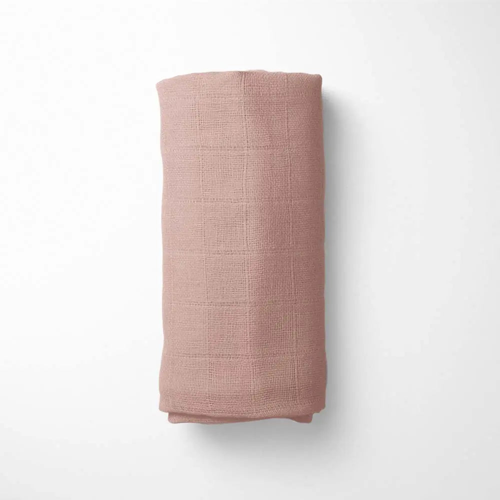 rolled brick red bamboo blanket, demonstrating the blanket's size and temperature-regulating properties