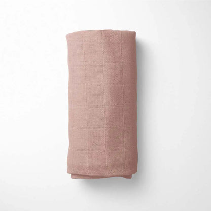 rolled brick red bamboo blanket, demonstrating the blanket's size and temperature-regulating properties