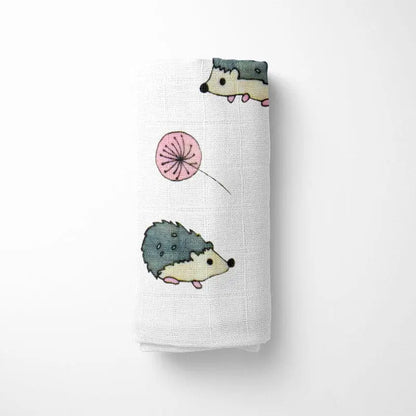 closeup of folded bamboo baby blanket showing detailed hedgehog design in various blues and greens on organic bamboo fabric