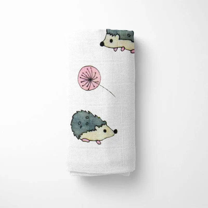 closeup of folded bamboo baby blanket showing detailed hedgehog design in various blues and greens on organic bamboo fabric