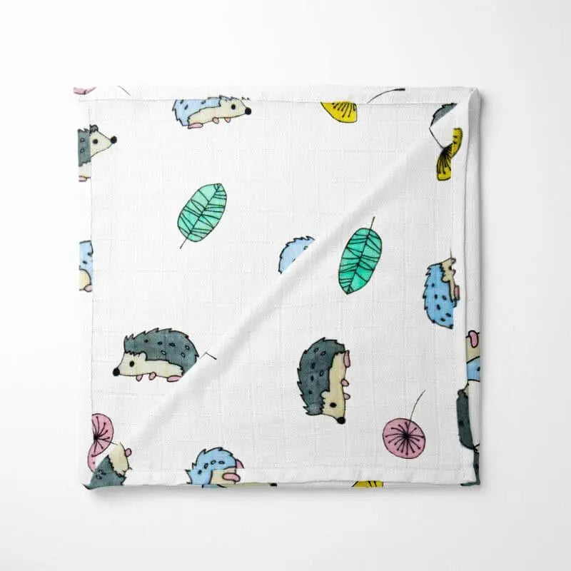 folded bamboo baby blanket featuring blue and green hedgehogs on white background with soft grid texture perfect for sensitive skin