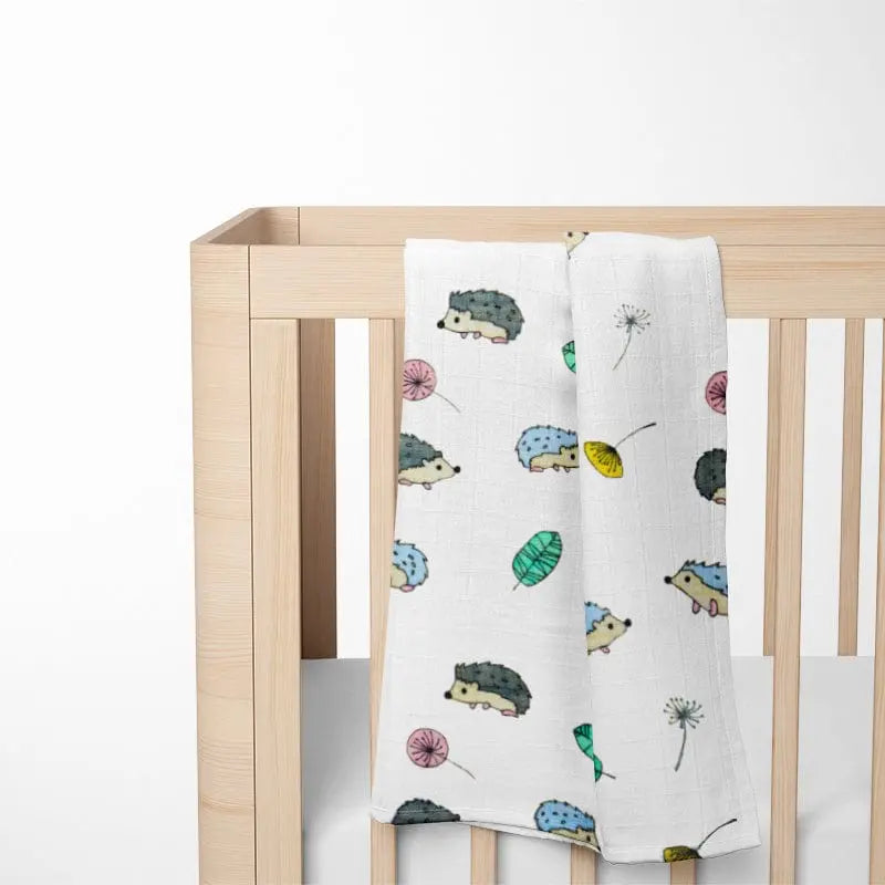 colorful hedgehog bamboo baby blanket displayed on wooden crib showing size and nature-inspired pattern that brings woodland charm to nursery decor
