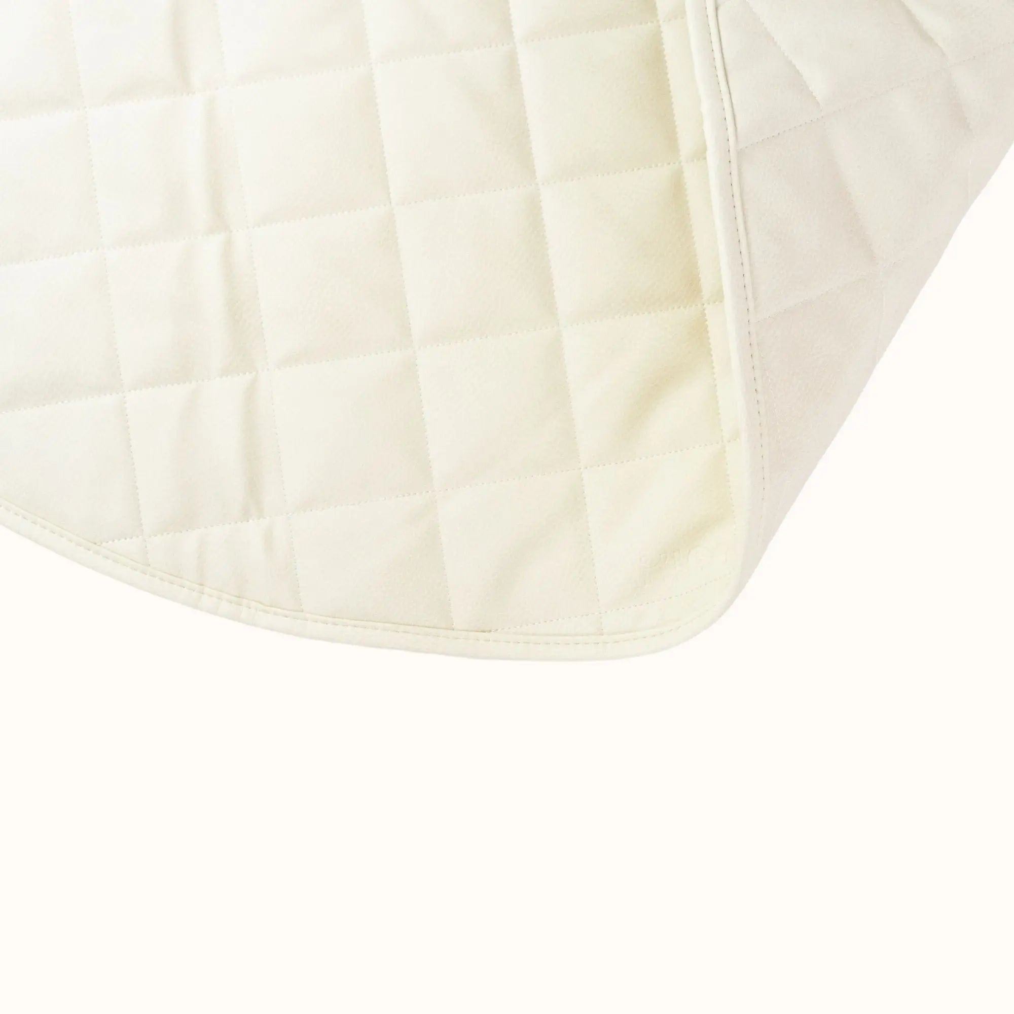 closeup of cream baby play mat showing quilted texture and premium vegan leather finish