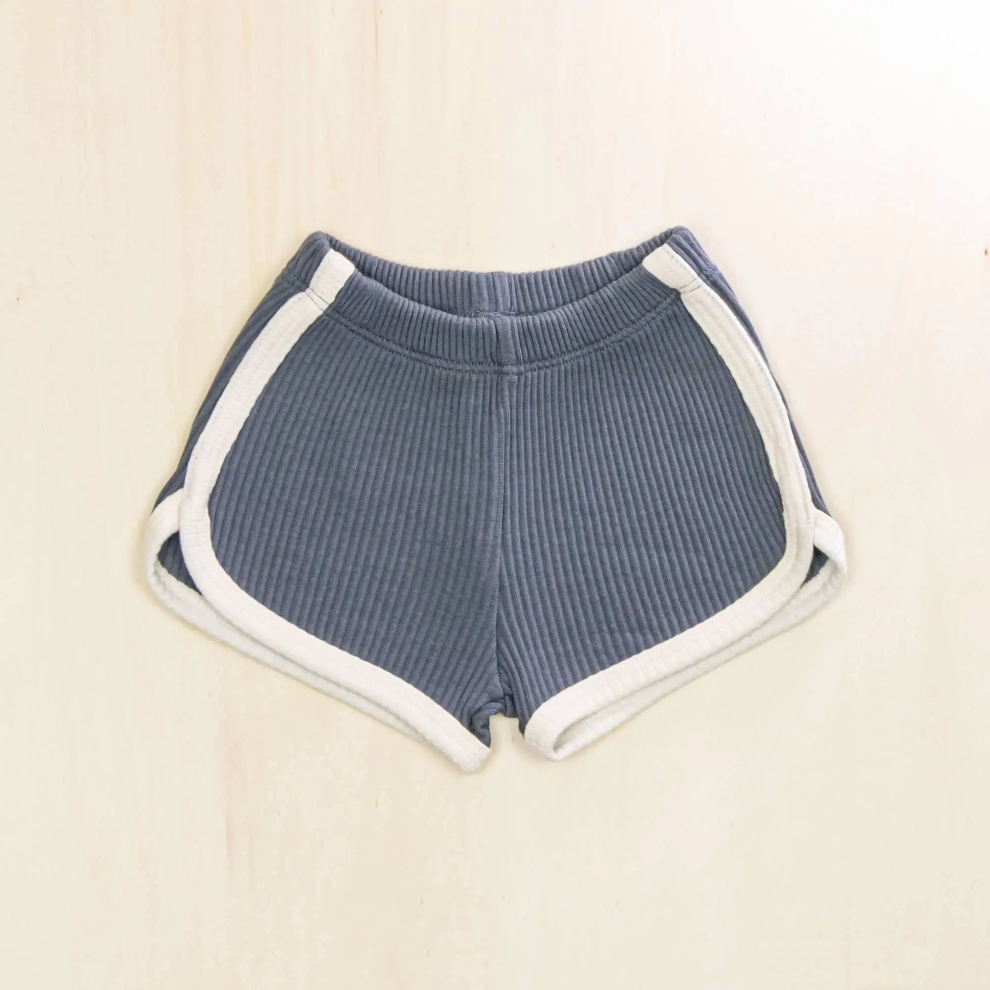 indigo blue organic cotton baby shorts with contrasting white trim, ribbed texture and retro athletic design