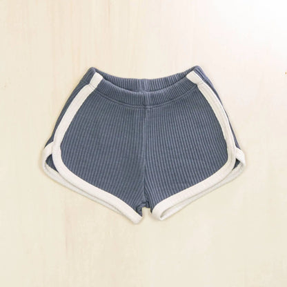 indigo blue organic cotton baby shorts with contrasting white trim, ribbed texture and retro athletic design