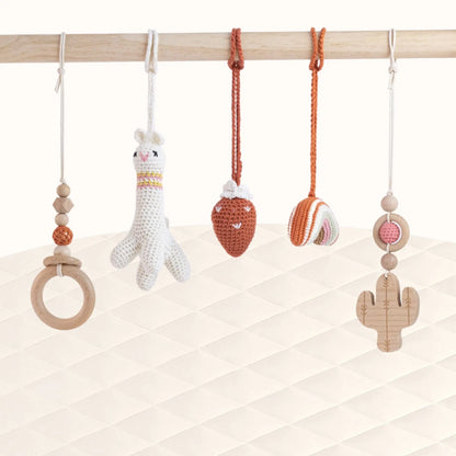 Front view of Lama with Strawberry Play Gym with all handcrafted toys visible showing desert-inspired theme