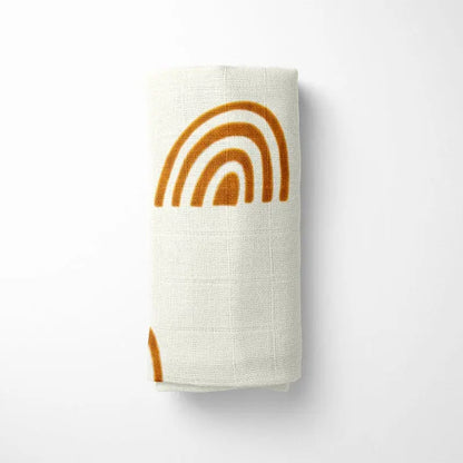 closeup of mono rainbow bamboo baby blanket showing detail of earthy terracotta arches and organic fabric texture