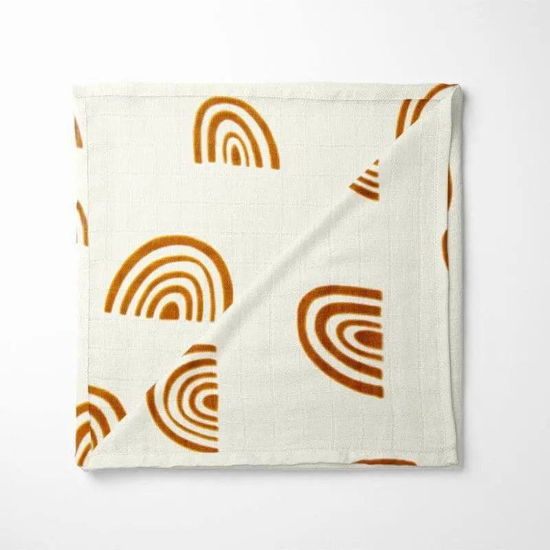 folded bamboo baby blanket with minimalist terracotta rainbow arches pattern on cream background showing soft grid texture