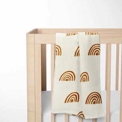 mono rainbow bamboo baby blanket displayed on wooden crib showing contemporary design that complements modern nursery decor