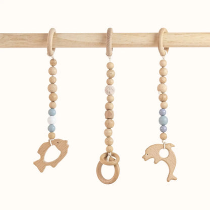 Close-up of Fishs Play Gym wooden ring toys showing smooth finish and natural grain for safe tactile exploration