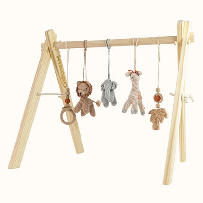 Natural wooden baby gym with crocheted safari animals including lion, elephant, and giraffe hanging from sturdy A-frame