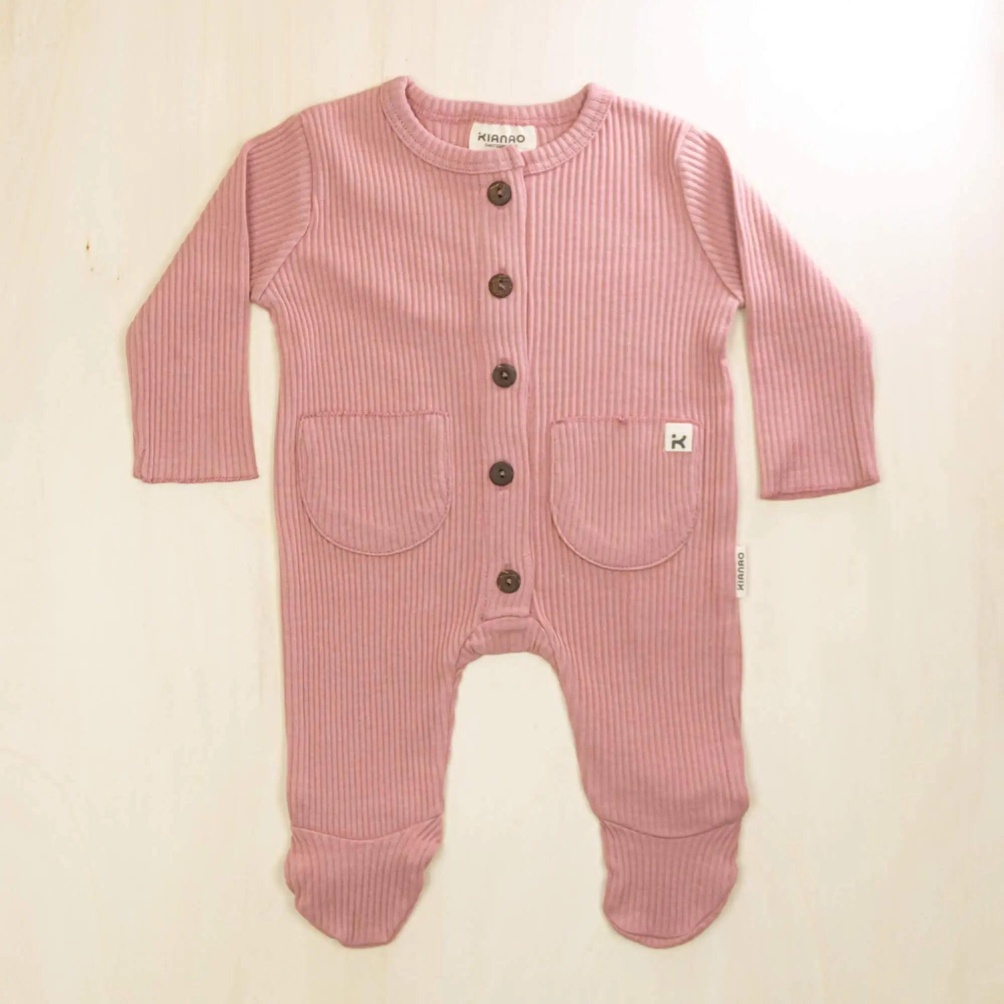 old rose organic cotton baby romper with integrated feet, front buttons and twin pockets, soft sustainable fabric for sensitive skin