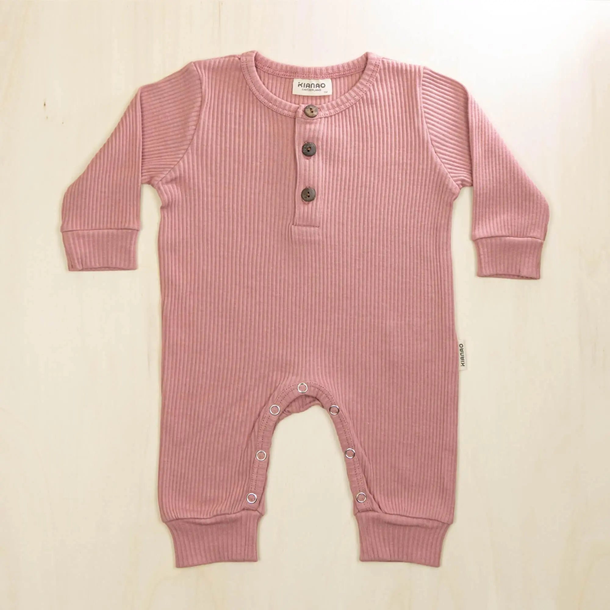old rose organic cotton jumpsuit featuring three-button henley neckline and soft stretchable fabric