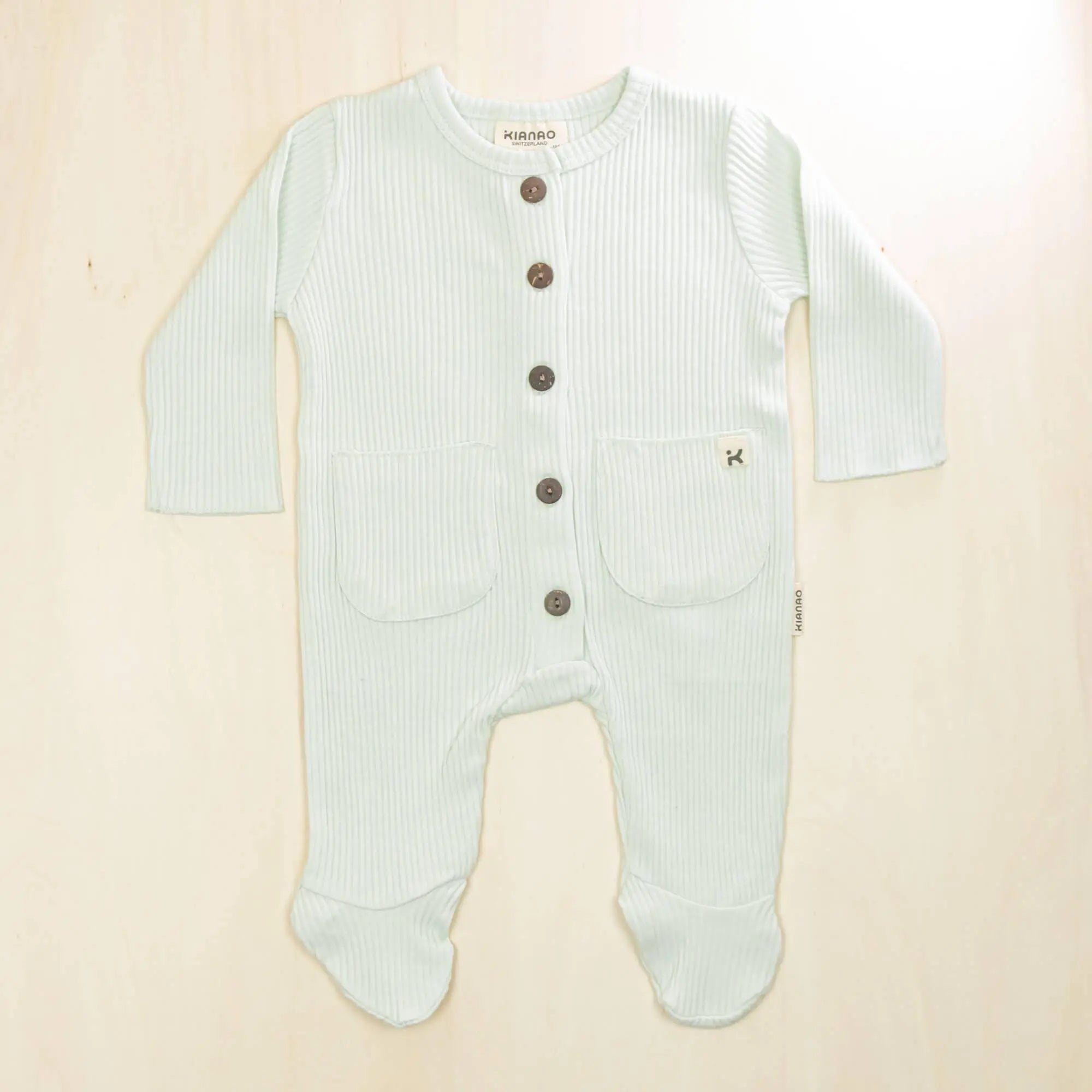 pale turquoise organic cotton baby romper with integrated feet, front buttons and pockets for easy dressing and diaper changes