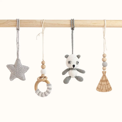 Close-up of Panda Play Gym toys showing detailed grey crochet panda, star, wooden teepee with beads and wooden ring toy