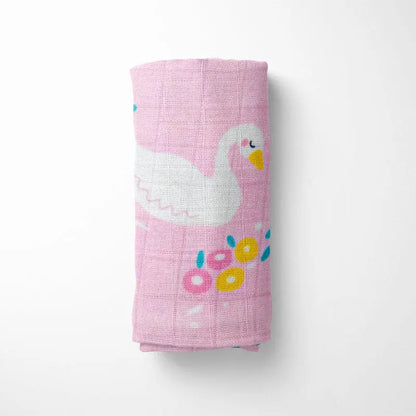 rolled pink bamboo baby blanket showing detailed swan pattern, compact for diaper bag storage