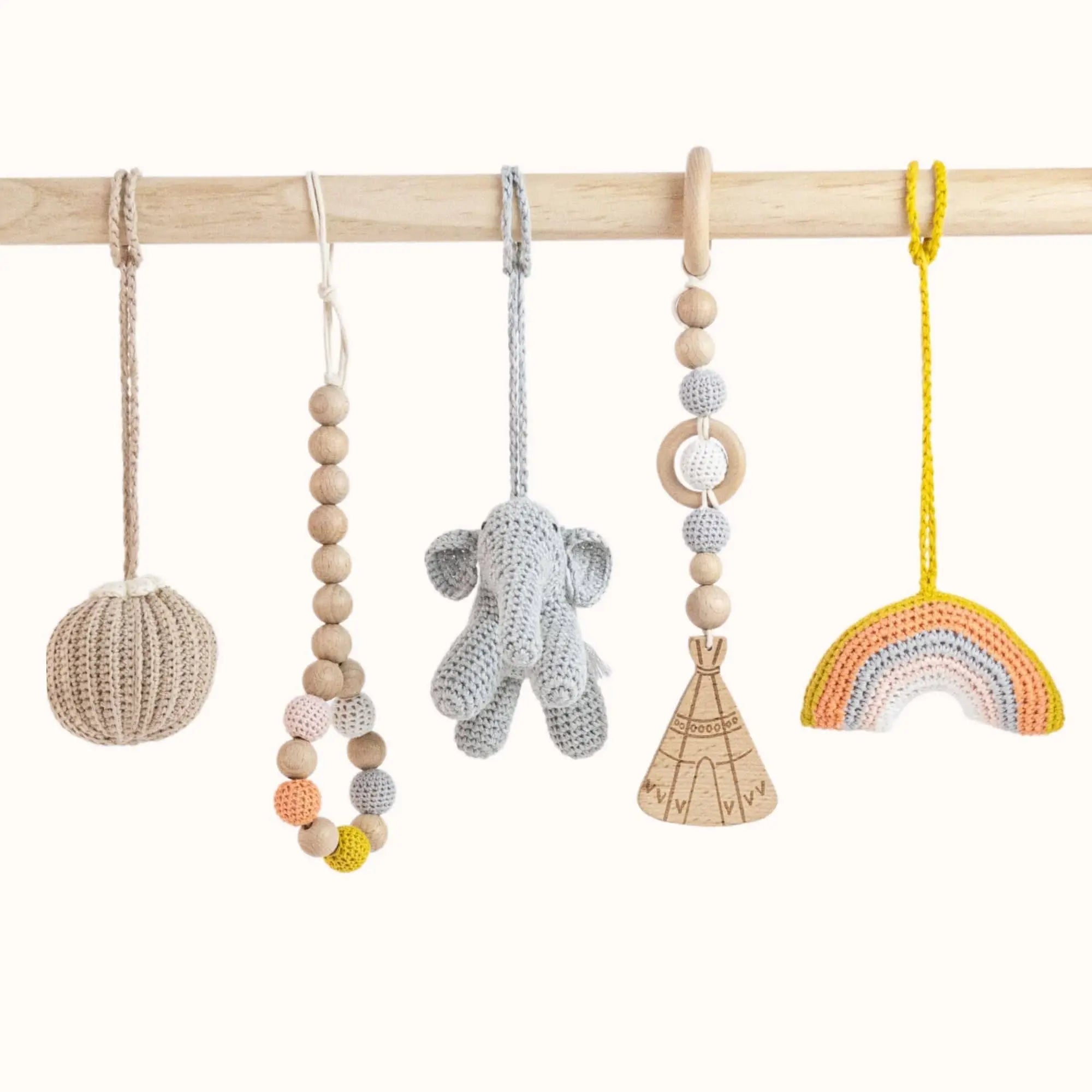 Close-up of Rainbow Play Gym toys showing grey elephant, wooden ring, and colorful geometric shapes for sensory play