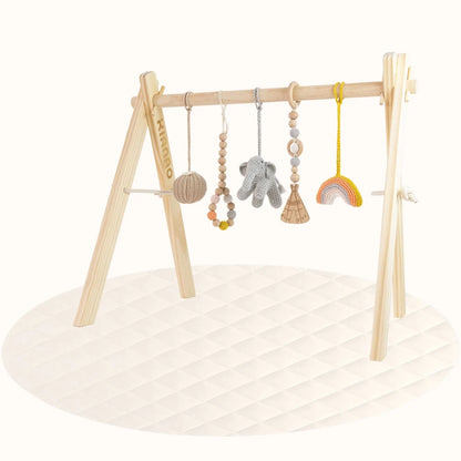 Side view of wooden Rainbow Play Gym showing sturdy A-frame design with hanging animal-themed toys