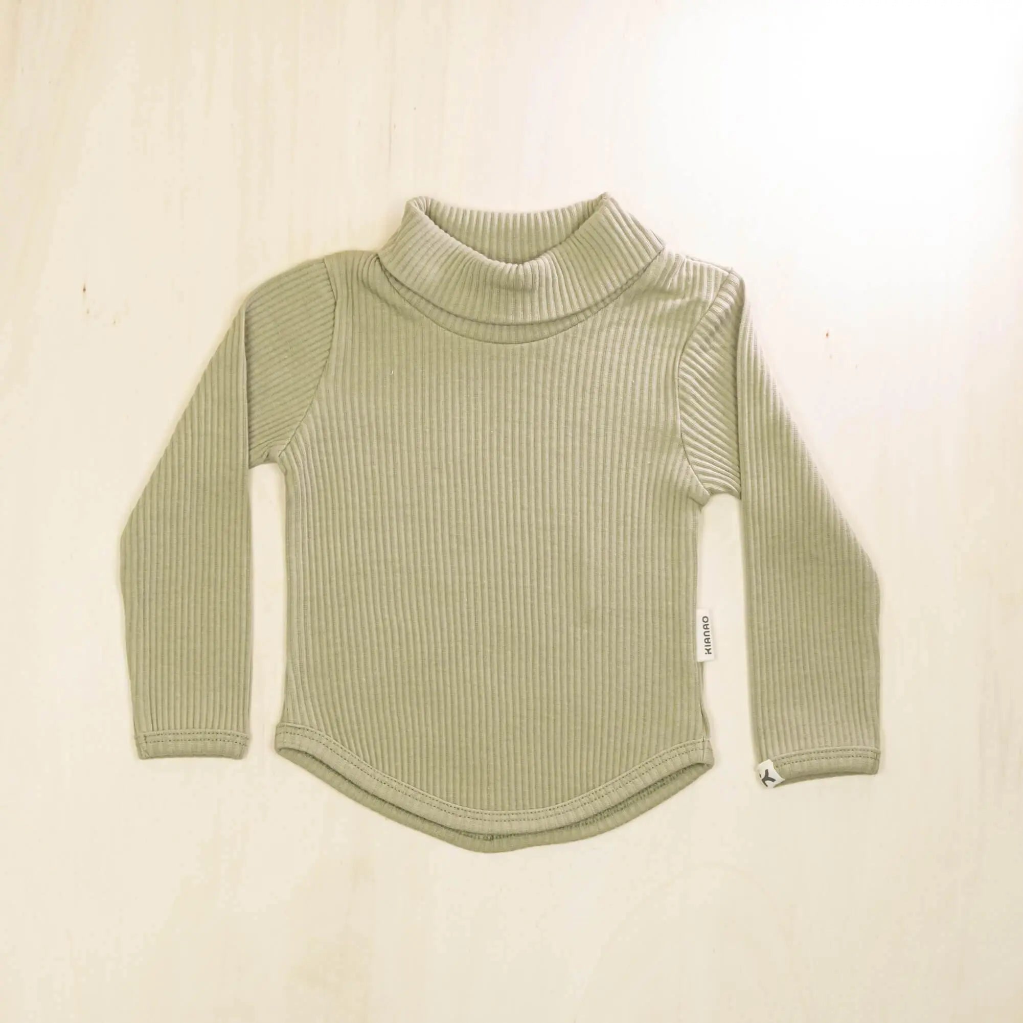 sage green organic cotton baby turtleneck sweater with long sleeves and curved hem, sustainable design for everyday warmth