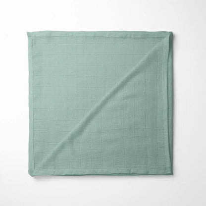 folded sage green bamboo baby blanket with soft grid texture, showcasing the natural organic fabric