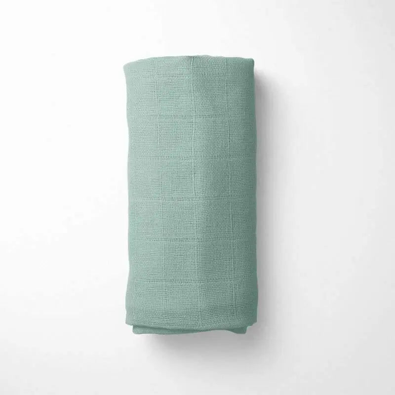 wrapped in sage green bamboo blanket, demonstrating the drape and size of the soft organic fabric