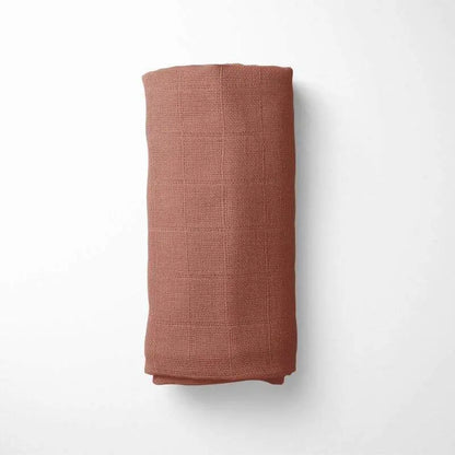 rolled with terracotta bamboo blanket during nap time, demonstrating the blanket's drape and comfort